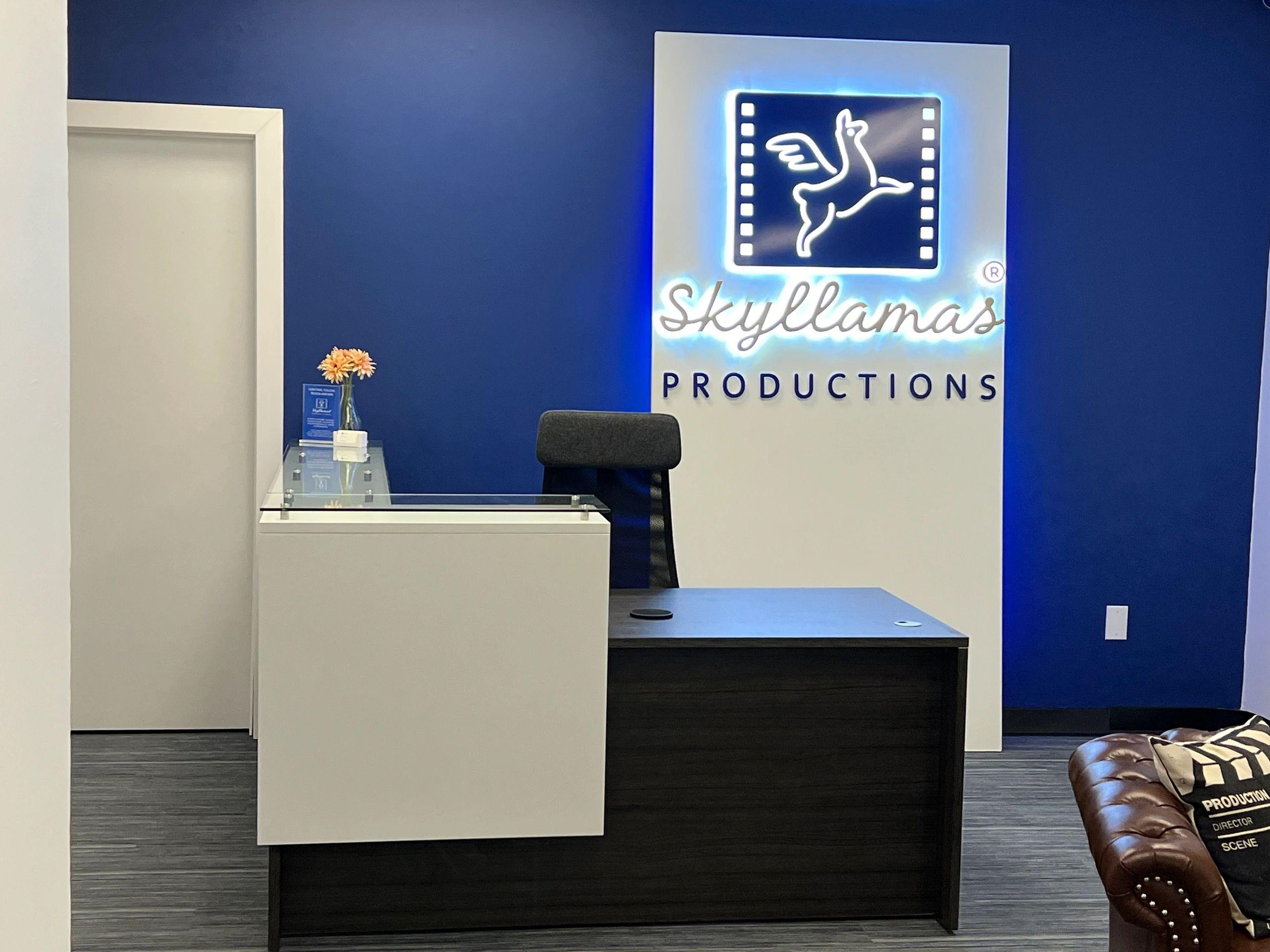 The Skyllamas Productions studio reception with the lit logo wall